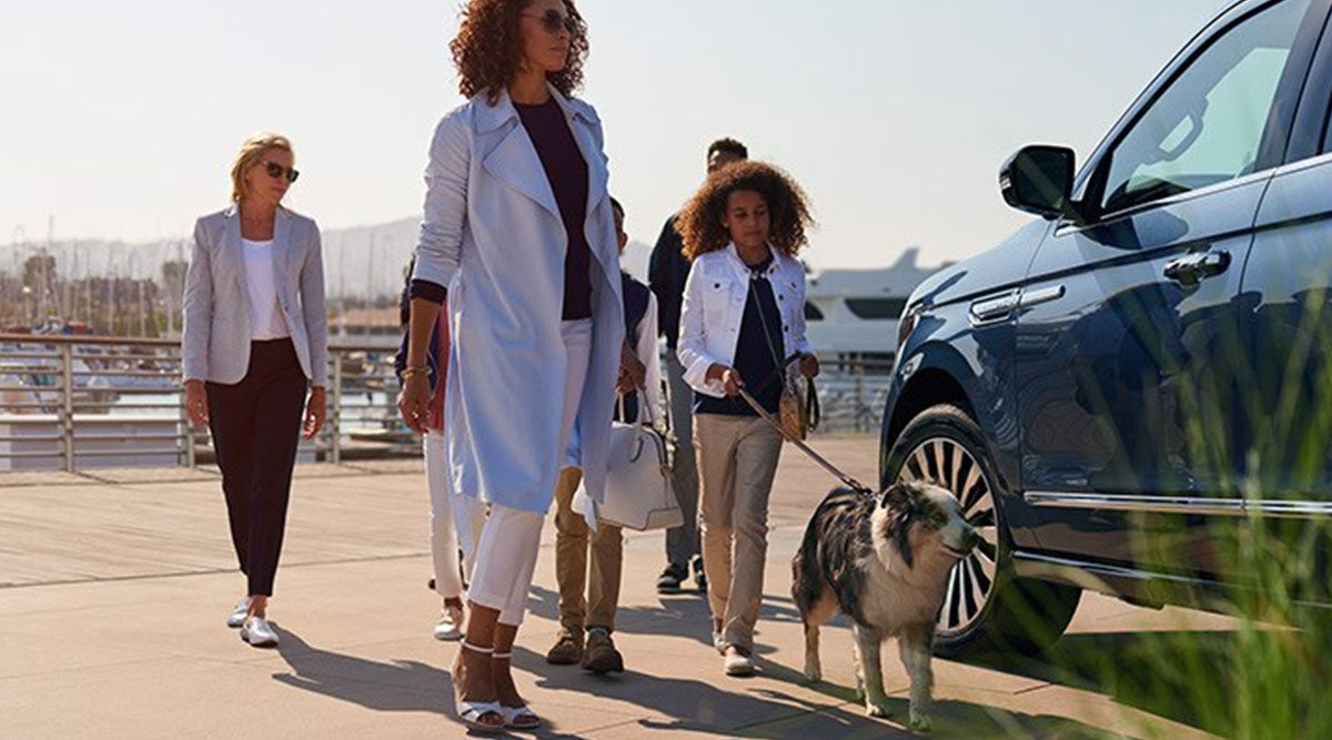 Family walking the a Licoln car