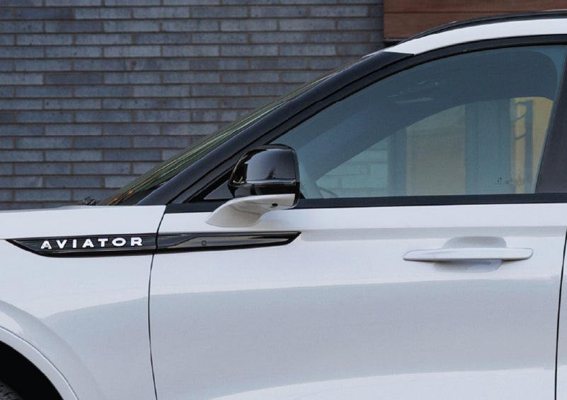 The driver’s side door and fender badging of a white 2026 Lincoln Aviator® SUV are showcased. | Lincoln of Troy in Troy MI