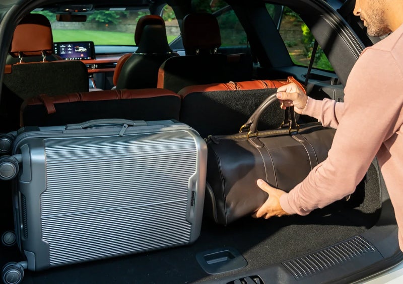 A man loads luggage into the rear of a 2026 Lincoln Aviator® SUV through the opened rear liftgate. | Lincoln of Troy in Troy MI