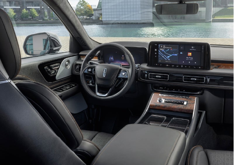 The interior of the 2026 Lincoln Aviator® SUV is shown parked with a view of a harbor through the windshield. | Lincoln of Troy in Troy MI