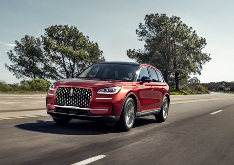 A 2026 Lincoln Corsair® SUV is shown being driven on a country road. | Lincoln of Troy in Troy MI