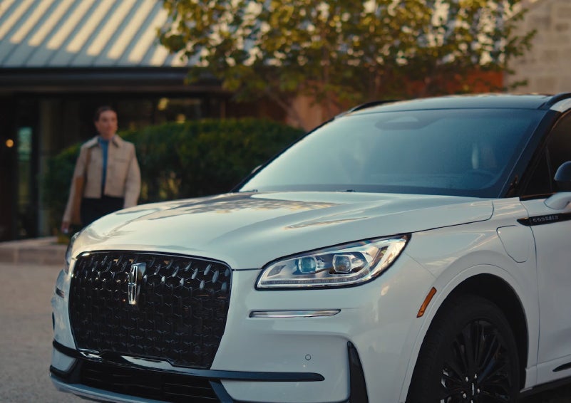 A person approaches a 2026 Lincoln Corsair® SUV as the Lincoln Embrace light sequence takes place. | Lincoln of Troy in Troy MI