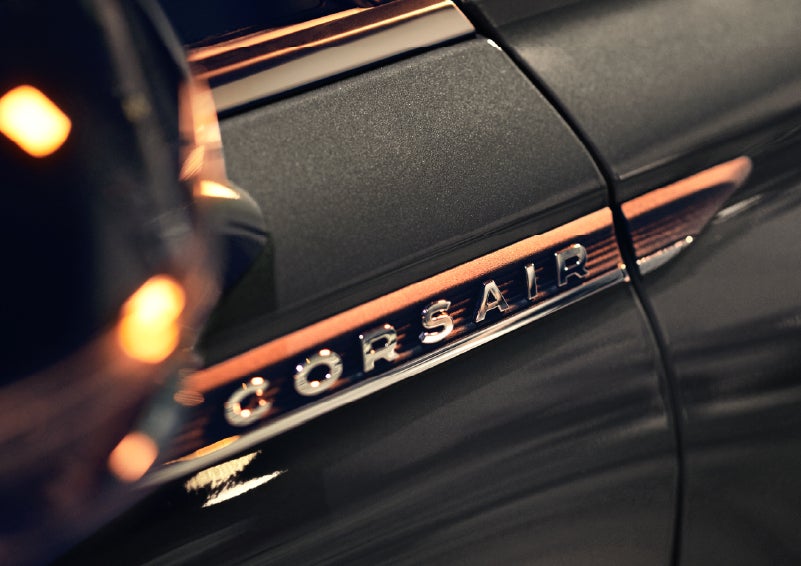 A 2026 Lincoln Corsair® SUV is shown being driven on a country road. | Lincoln of Troy in Troy MI