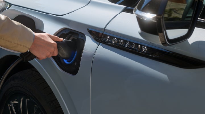 A hand is plugging in a 2026 Lincoln Corsair® Grand Touring Plug-in Hybrid SUV. | Lincoln of Troy in Troy MI