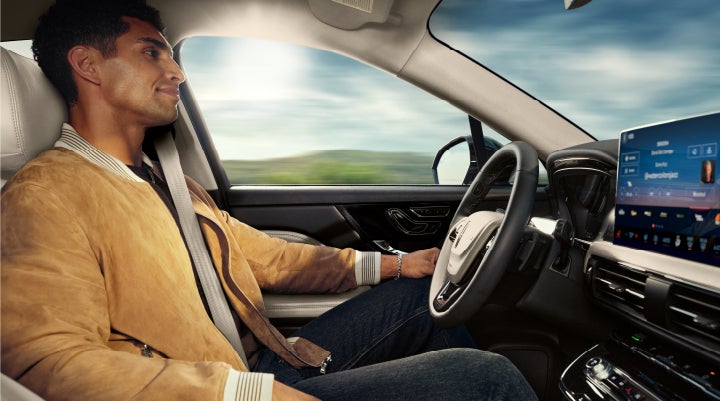 A person is shown using Lincoln BlueCruise hands-free highway driving technology on a divided highway in a hands-free Blue Zone. | Lincoln of Troy in Troy MI