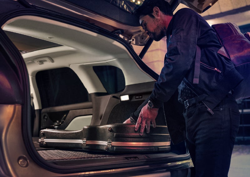 A man is shown loading cargo into the rear of a 2026 Lincoln Corsair® SUV with the second-row seats folded flat. | Lincoln of Troy in Troy MI