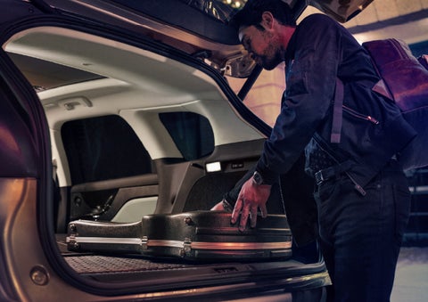 A man is shown loading cargo into the rear of a 2026 Lincoln Corsair® SUV with the second-row seats folded flat. | Lincoln of Troy in Troy MI
