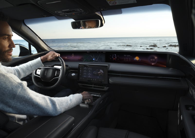 A driver of a parked 2026 Lincoln Nautilus® SUV takes a relaxing moment at a seaside overlook while inside his Nautilus. | Lincoln of Troy in Troy MI