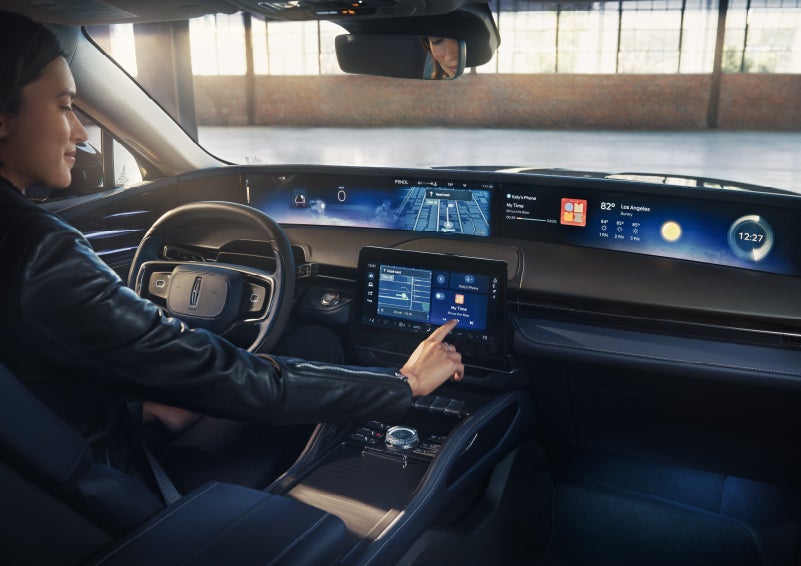 The driver of a 2026 Lincoln Nautilus® SUV interacts with the center touchscreen. | Lincoln of Troy in Troy MI