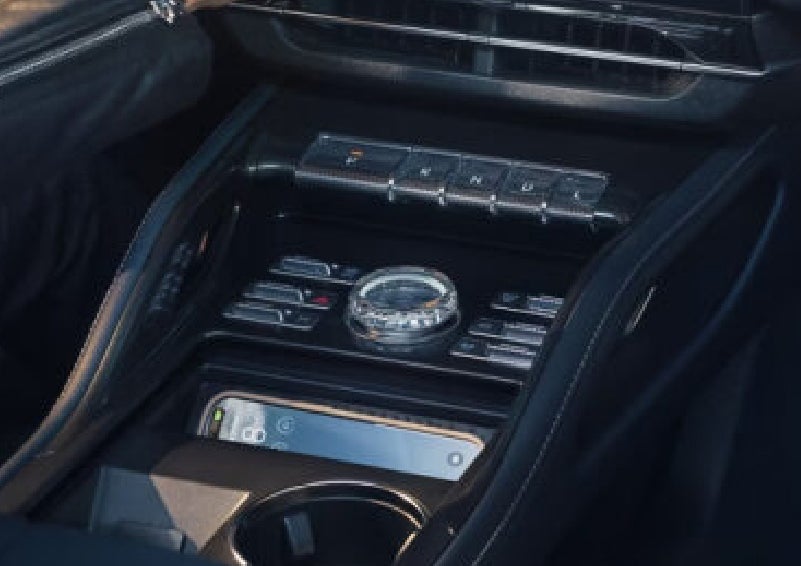 A smartphone is shown charging in the wireless charging pad. | Lincoln of Troy in Troy MI