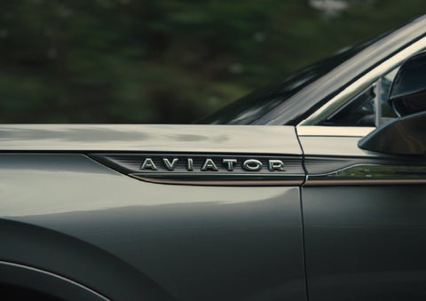 The driver’s side door and fender badging of a gray 2027 Lincoln Aviator® SUV are showcased. | Lincoln of Troy in Troy MI