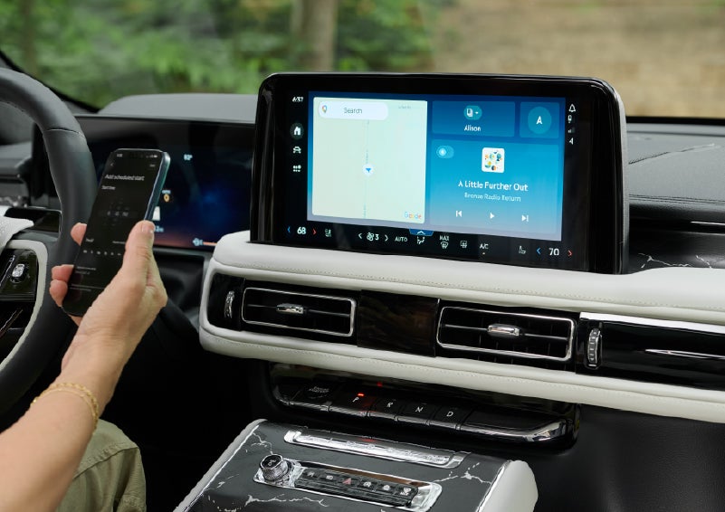 A person pairs thier phone with the center touchscreen of a 2027 Lincoln Aviator® Black Label™ SUV | Lincoln of Troy in Troy MI