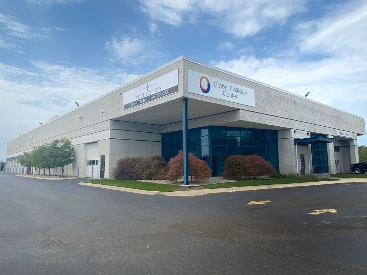 Exterior view of a Global Collision Center facility, featuring a large modern commercial building
