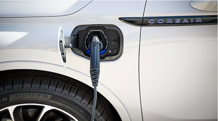 An electric charger is shown plugged into the charging port of a Lincoln Corsair® Grand Touring mode…