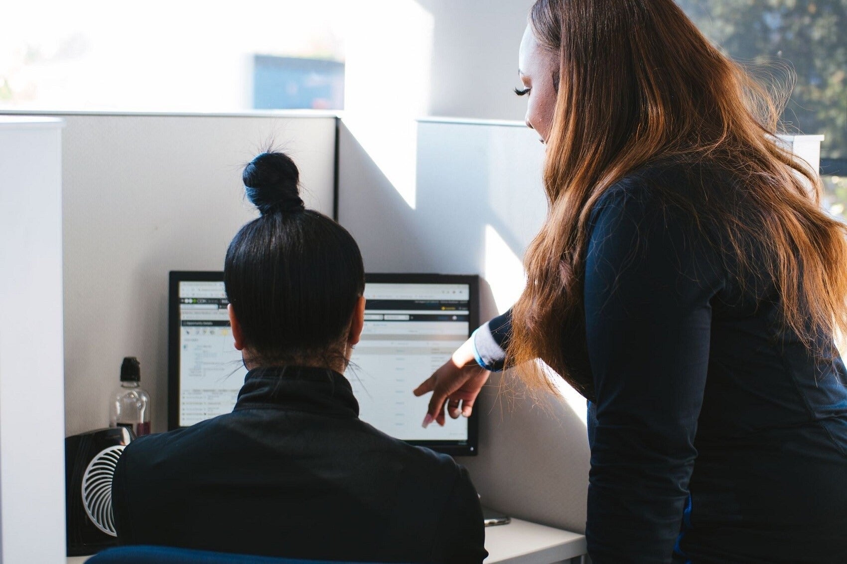 Worker looking at computer screen while manager points to screen